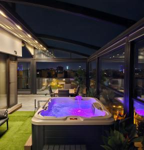 eine Whirlpool-Badewanne auf dem Balkon eines Hauses in der Unterkunft Crown Penthouse - Luxurious, Spa & Vista , by Uni88 ApartHotel in Bukarest