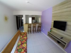 a living room with a flat screen tv and a couch at Flat Vila dos Milagres in São Miguel dos Milagres