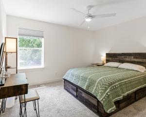 a bedroom with a bed and a desk and a window at Silverside House - Pet Friendly - Centrally Located in Muskegon