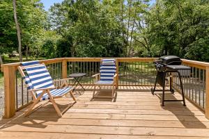 two chairs and a grill on a wooden deck at Silverside House - Pet Friendly - Centrally Located in Muskegon