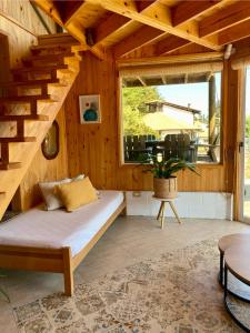 a wooden room with a bed and a staircase at Espectacular Cabaña con acceso a la playa in Puchuncaví