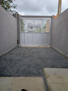 eine leere Garage mit Tor und Fenster in der Unterkunft Casa bananeira in Bombinhas