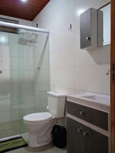 ein Badezimmer mit Toilette, Dusche und Waschbecken in der Unterkunft Casa bananeira in Bombinhas