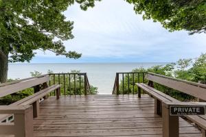 a wooden walkway to the beach with two benches at Red Cottage Cute Holland cottage walk to beach in Holland