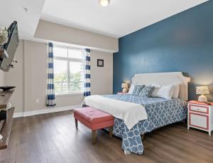 a bedroom with a bed with a blue wall at Experience comfort at Quill Haven - Pet Friendly in Grand Haven