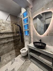 a bathroom with a toilet and a sink and a mirror at EVO Apartament de Lux André in Sibiu