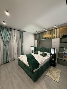 a bedroom with a green bed and a window at EVO Apartament de Lux André in Sibiu