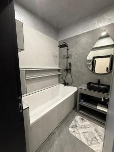 a bathroom with a bath tub and a sink at EVO Apartament de Lux André in Sibiu