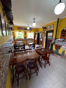 a restaurant with wooden tables and chairs and yellow walls at Pousada Weiss Blau in Ilha Comprida