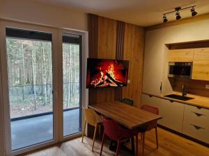 a kitchen with a wooden table with a fire in it at Green peace-Bjelašnica in SJJ