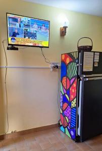 einen TV an einer Wand neben einem Kühlschrank in der Unterkunft DEPTO en SANTA TERESITA PARA 4 PERSONAS- EXCELENTE UBICACIÓN- NO se aceptan mascotas- 5 cuadras Playa - 2 Bingo y cerca centro y Bosque - CONSULTAR DISPONIBILIDAD POR CELULAR in Santa Teresita + 8 Fotos