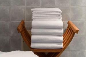 une pile de serviettes sur un support dans une salle de bain dans l'établissement Casa do Farol - Charming Townhouse, à Lagos 15 autres photos