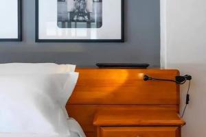 - un lit avec une tête de lit en bois et une lampe dans l'établissement Casa do Farol - Charming Townhouse, à Lagos