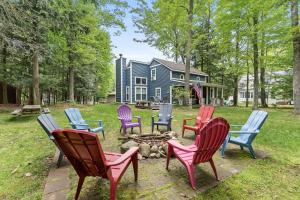 a group of chairs around a fire pit in front of a house at Experience the charm of Silver Lake at Parrothead Retreat in Mears