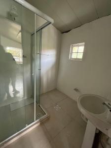 Un baño con ducha de cristal y lavabo. en Fisherman's House, en Angra dos Reis