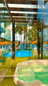 a bath tub in a room with a swimming pool at Pousada Bella Praia in Torres