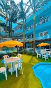 a patio with tables and umbrellas next to a pool at Pousada Bella Praia in Torres