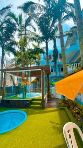 a house with palm trees and a swimming pool at Pousada Bella Praia in Torres