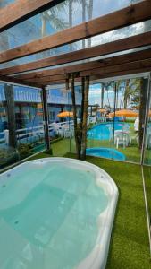 a hot tub in the grass next to a pool at Pousada Bella Praia in Torres