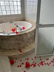 a bathroom with red hearts on the floor next to a tub at Pousada Bella Praia in Torres