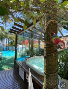 a jacuzzi tub in a tree next to a pool at Pousada Bella Praia in Torres