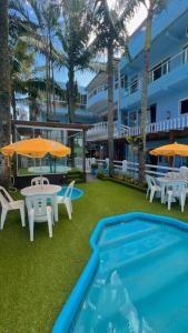 a patio with a table and chairs and a pool at Pousada Bella Praia in Torres