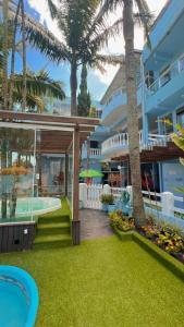 a resort with a swimming pool and palm trees at Pousada Bella Praia in Torres