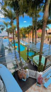 a resort with palm trees and a swimming pool at Pousada Bella Praia in Torres