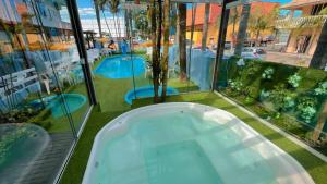 a tub in a room with a view of a pool at Pousada Bella Praia in Torres