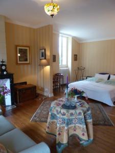 Un dormitorio con una cama y una mesa con flores. en Domaine Mongiron, en Nérigean