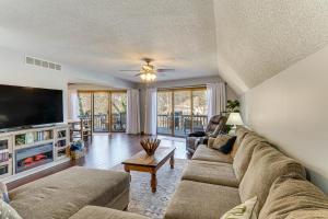 a living room with a couch and a flat screen tv at Lakefront Home with Dock and Decks in Gravois Mills! in Gravois Mills