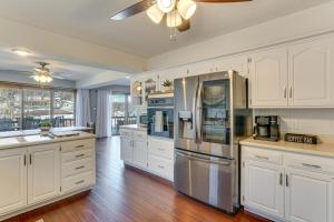 a kitchen with white cabinets and a stainless steel refrigerator at Lakefront Home with Dock and Decks in Gravois Mills! in Gravois Mills