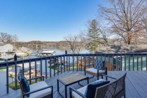 a balcony with chairs and tables and a view of a marina at Lakefront Home with Dock and Decks in Gravois Mills! in Gravois Mills