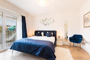 ein Schlafzimmer mit einem Bett und einem blauen Stuhl in der Unterkunft Swiss Flat Rental in Lausanne