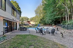 a patio with chairs and a table and a pool at Hillside Cottage- Great Vacation Rental with Private Pool in Muskegon