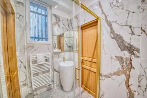 a bathroom with a toilet and a sink and a window at L'étape Champenoise in Reims +33 photos