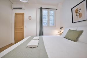 a white bed with two towels on it in a bedroom at L'étape Champenoise in Reims