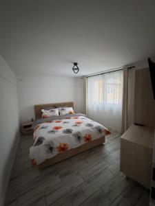 una camera da letto con un letto con un piumone floreale di ARY Montan a Petroşani