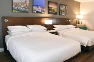 two beds in a hotel room with white pillows at The Fontana Hotel in Indianapolis