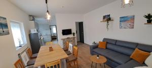 a living room with a couch and a table at Aqua apartmanház Gyenesdiás in Gyenesdiás