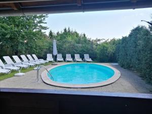 a swimming pool with lounge chairs and a swimming pool at Aqua apartmanház Gyenesdiás in Gyenesdiás