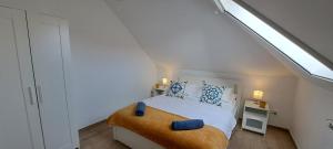 a white bedroom with a bed with blue pillows at Aqua apartmanház Gyenesdiás in Gyenesdiás +46 photos