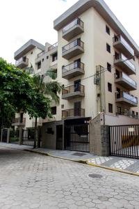 an apartment building with a fence in front of it at Ap 3 quartos praia grande vista pro mar área nobre in Ubatuba