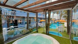 a bath tub in a room with a pool at Pousada Bella Praia in Torres