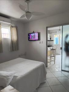 a bedroom with a bed and a tv on the wall at Pousada Bella Praia in Torres