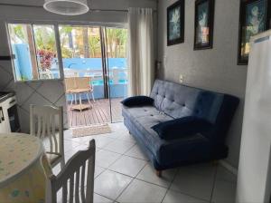 a living room with a blue couch and a patio at Pousada Bella Praia in Torres