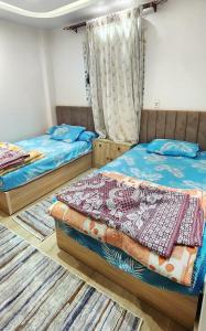 2 Einzelbetten in einem Zimmer mit Teppichen in der Unterkunft Gardenia City 652-1 in Kairo
