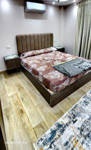 Schlafzimmer mit einem Bett und Holzböden in der Unterkunft Gardenia City 652-1 in Kairo