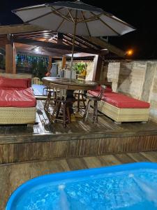 a patio with a table and chairs and an umbrella at Recanto CostaCastilho in Bertioga