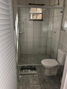 a small bathroom with a toilet and a window at Recanto CostaCastilho in Bertioga